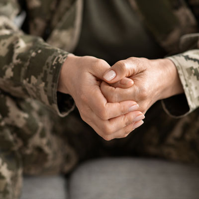An unidentified soldier clasping their hands together