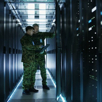 Two soldiers standing in the hallway of a data storage center