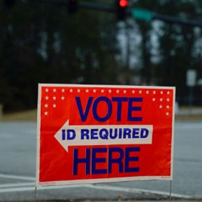 A voter ID required sign near the road