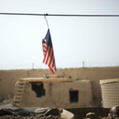 the American flag hanging from a wire in front of a military compound