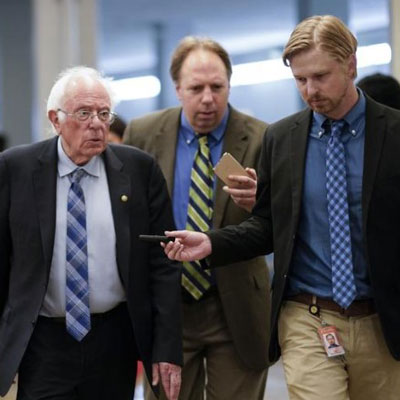 Sen. Bernie Sanders with reporters as senators rush to the chamber for votes ahead of the recess, facing standoffs on infrastructure, police and voting reform and a Jan. 6 commission.