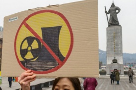 Woman holds up an anti-nuclear sign