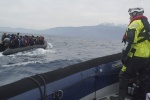 A man watching a flotable raft of refugees