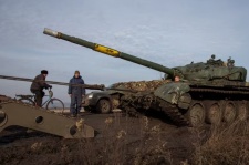 A broken tank is pulled to a truck near the frontline town of Bakhmut in Ukraine