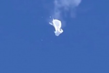 The suspected Chinese spy balloon drifts to the ocean after being shot down