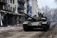 A Ukrainian tank drives down a street in the heavily damaged town of Siversk