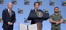 Fumio Kishida speaking at a podium with US President Biden and Ukrainian President Zelenskyy