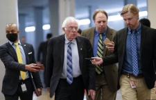 Sen. Bernie Sanders with reporters as senators rush to the chamber for votes ahead of the recess, facing standoffs on infrastructure, police and voting reform and a Jan. 6 commission.
