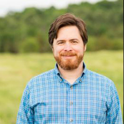 Peter Henne standing in front of a grassy background