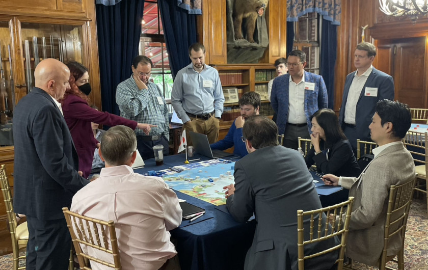 Game participants around a table, looking at a map