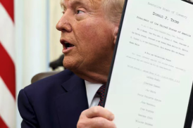 U.S. President Donald Trump holds up one of a flurry of executive orders signed within days of taking office. (Kevin Lamarque/Reuters)