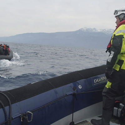 A man watching a flotable raft of refugees