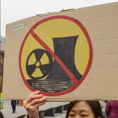 Woman holds up an anti-nuclear sign