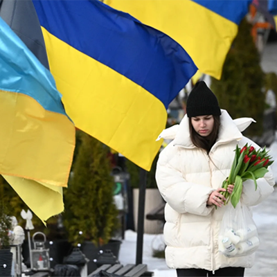 A mourner holds flowers on Valentine's Day at the Lychakiv Military Cemetery in Lviv, on February 14, 2026, amid the Russian invasion of Ukraine.