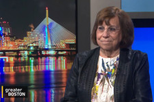 Carol Saivetz sitting in the GBH news room